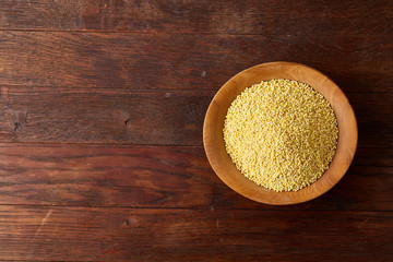 A wooden dish with lentils on rustic wooden background, top view, close-up, selective focus.