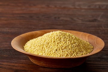 A wooden dish with lentils on rustic wooden background, top view, close-up, selective focus.