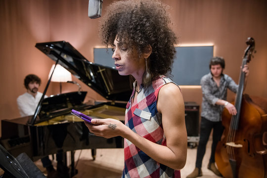 Singer checking smartphone during rehearsal