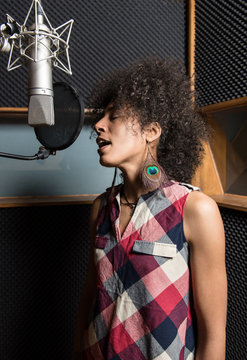 Young woman singing in studio