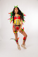 Skinny young dark haired hispanic woman in Carnaval costume and athletic shoes posing on clean white background