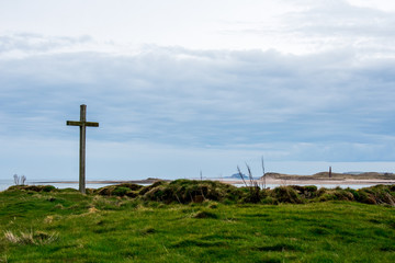 A wooden cross, on a grassy island