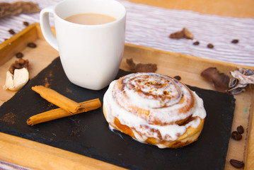 Tasty breakfast with homemade cinnamon roll and fresh coffee. Food background.
