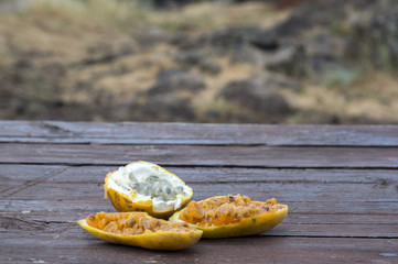 Banana maracuja and lemon maracuja fruits on wooden table, halved ready to eat, fruit pulp with seeds