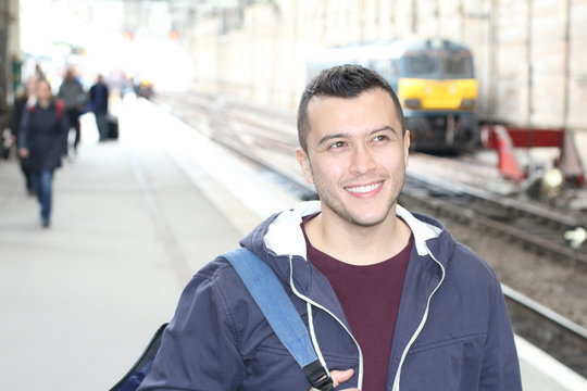 Smiley ethnic male waiting for a train