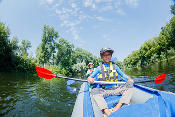 Happy boy kayaking on the river on a sunny day during summer vacation