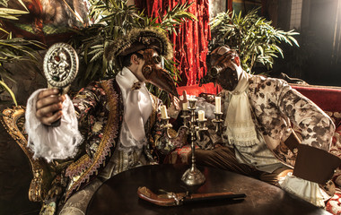 Actors in steam punk masks and antique costumes indoor.