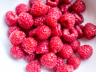 fresh raspberries in white bowl detail