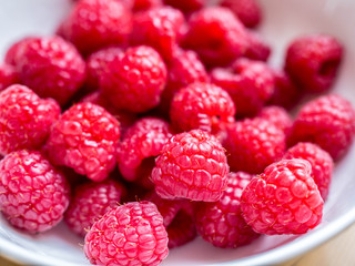 fresh raspberries in white bowl detail