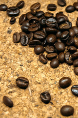 Fresh black coffe beans on cork table