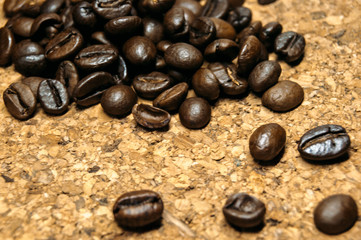 Fresh black coffe beans on cork table