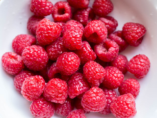 fresh raspberries in white bowl detail