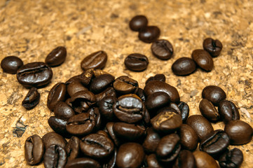 Fresh black coffe beans on cork table