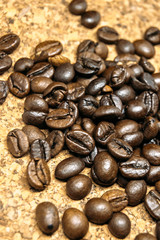 Fresh black coffe beans on cork table