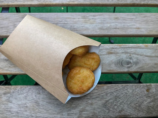 Chicken Nuggets in Kraft Paper Box on a Wooden Table Background