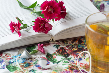 Cup of tea and book with flowers
