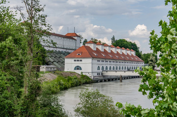 Obraz premium Old power station for energy generation on river bank with dam behind building