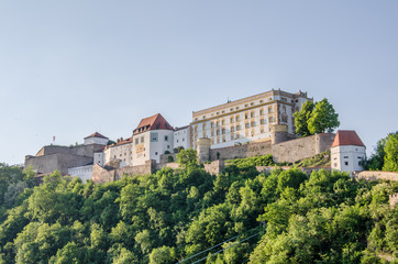 Fototapeta na wymiar Castle on river bank in city of Passau in Germany, Bavaria