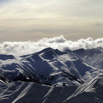 Snowy mountains and sky with sunlight clouds