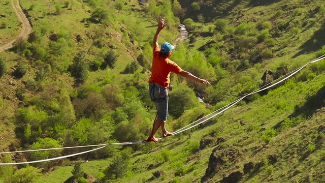 Funambulist at sunset in the mountains enjoying nature. slow motion