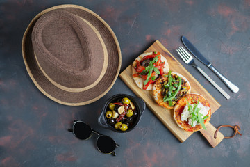 Delicious tapas set. Small sandwiches with goat cheese, chopped olives and nuts, cured tomato and roasted bell pepper.