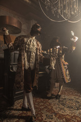 Actors in steam punk masks and antique costumes indoor.