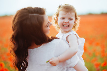 mother and daughter playing in flower field