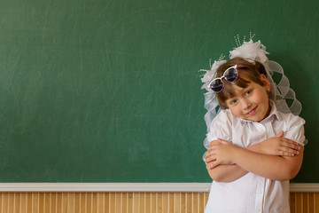 The girl is standing near the chalkboard and enjoying her success.