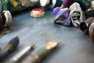 Bright oil paints in a tube on a dirty palette. Paints in use.