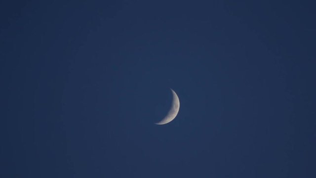 Incomplete moon in the blue sky after sunset