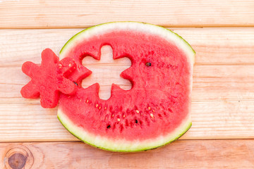 slices of watermelon on wooden table, mediterranean garden background