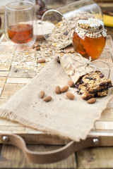 Oatmeal and honey in a jar, a banana on a wooden table. Healthy breakfast. Vintage photo.