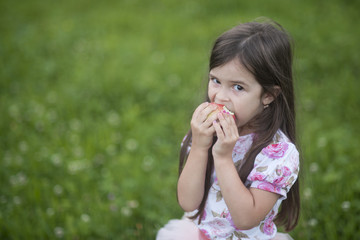 Little girl portrait eating red apple