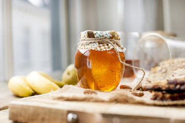 tea, nuts, honey, in a jar and a banana on a wooden table near the eye. Healthy breakfast. Vintage photo