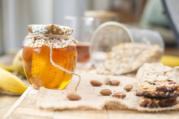 tea, nuts, honey, in a jar and a banana on a wooden table near the eye. Healthy breakfast. Vintage photo