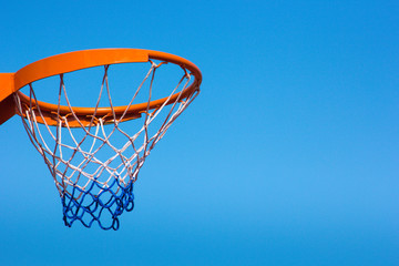 Basketball hoop against the blue sky, close-up