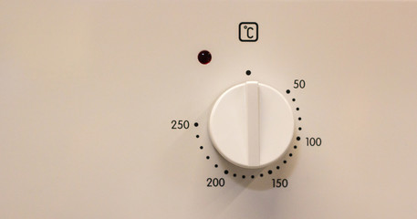 Close-up hand setting cooking mode or temperature on oven
