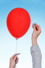 hand holding needle near balloon. isolated on white. Danger concept.
