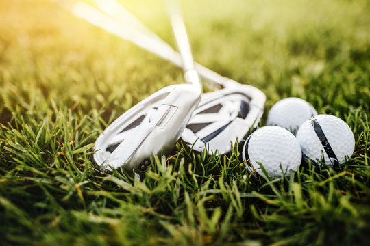 Golf ball and golf club in bag on green grass