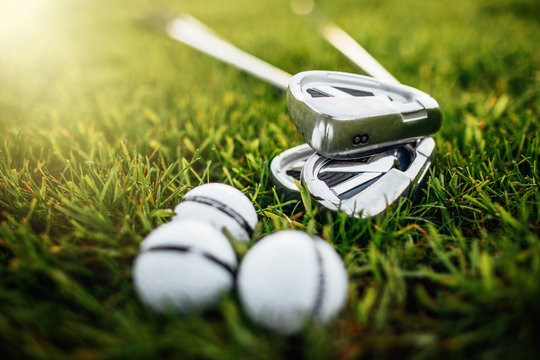Golf ball and golf club in bag on green grass