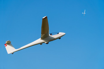 Two white gliders flying in clear blue sky. Concept of success, achievement of high goal