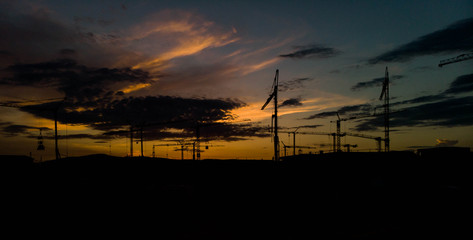 silhouette of construction tower crane group with sunset sky background