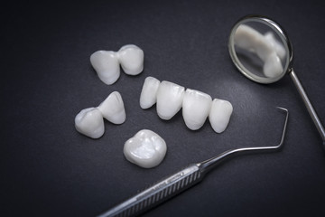 Dental tools and zircon dentures on a dark background - Ceramic veneers - lumineers