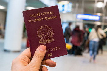 man holding italian passport in the airport