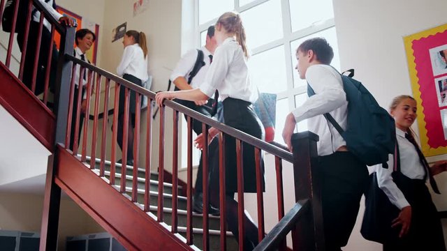 Teenage Students In Uniform Walking Down Stairs Between Lessons