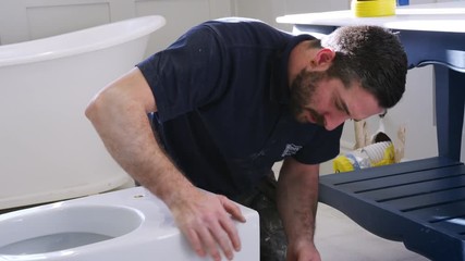 Plumber Cleaning New Toilet Basin Before Fitting