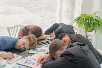 Group businessmen and businesswomen sleeping resting on workplace during work meeting, concept of...