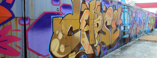 Street art. Abstract background image of a full completed graffiti painting in beige and orange tones with the subway train