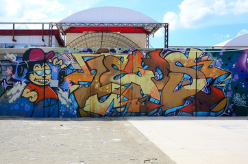 Street art. Abstract background image of a full completed graffiti painting in beige and orange tones with cartoon character