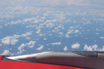 view from the window of an airplane on clouds and sky background